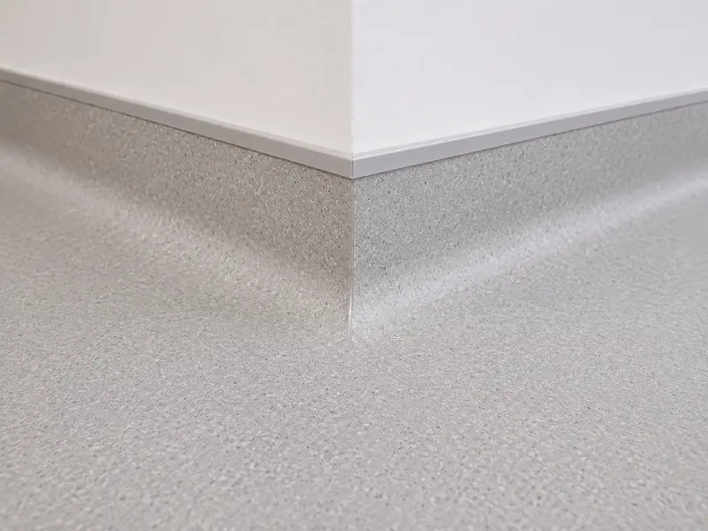 Heat-welded vinyl sheet seam and coved skirting detail in a UAE healthcare facility
