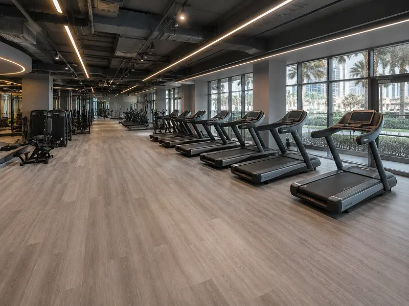 SPC vinyl flooring with Class 34 wear classification installed in a Dubai commercial gym cardio zone